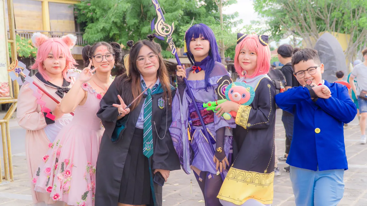 Group of cosplayers in wigs, uniforms and robes posing together at an outdoor fan event Group of six cosplayers in pink wigs, a school robe, a purple outfit and a blue jacket posing together outdoors, showing easy cosplay ideas side by side